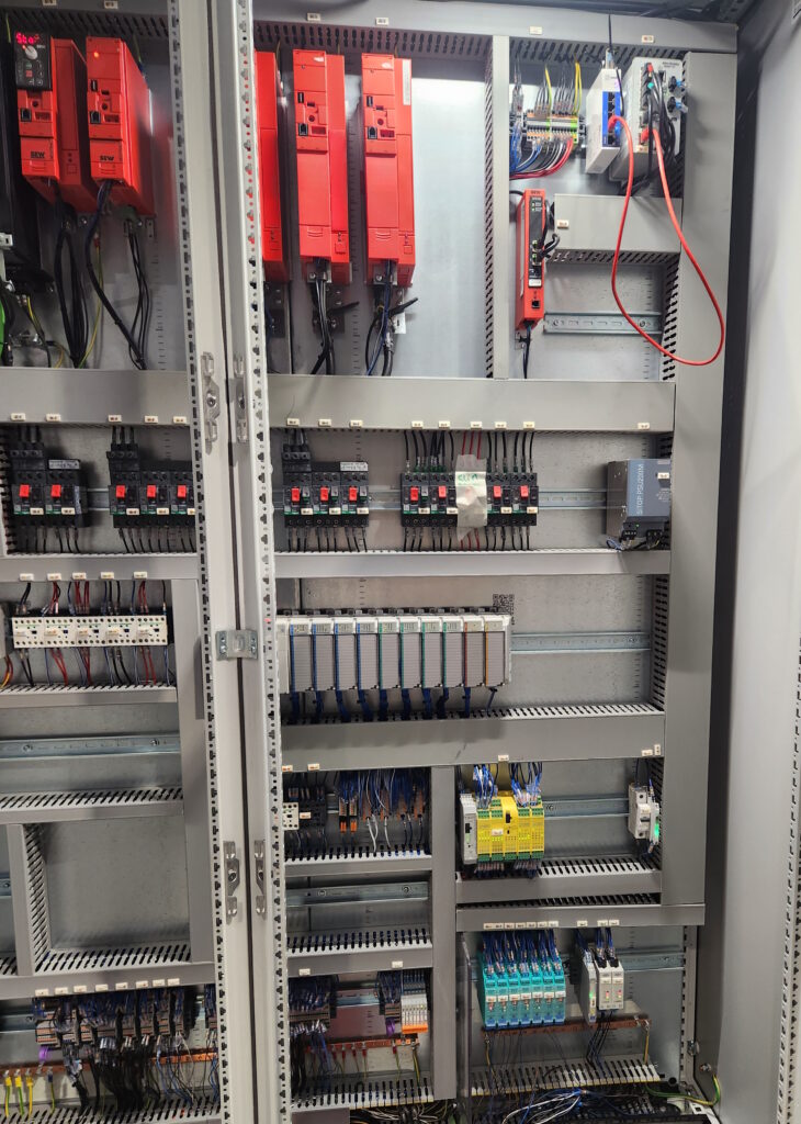 Armoire principale avec automate Rockwell CompactLogix 5370, axes Sew Movidrive B, variateurs Sew Movitrac et relais de sécurité programmable Phoenix Contact